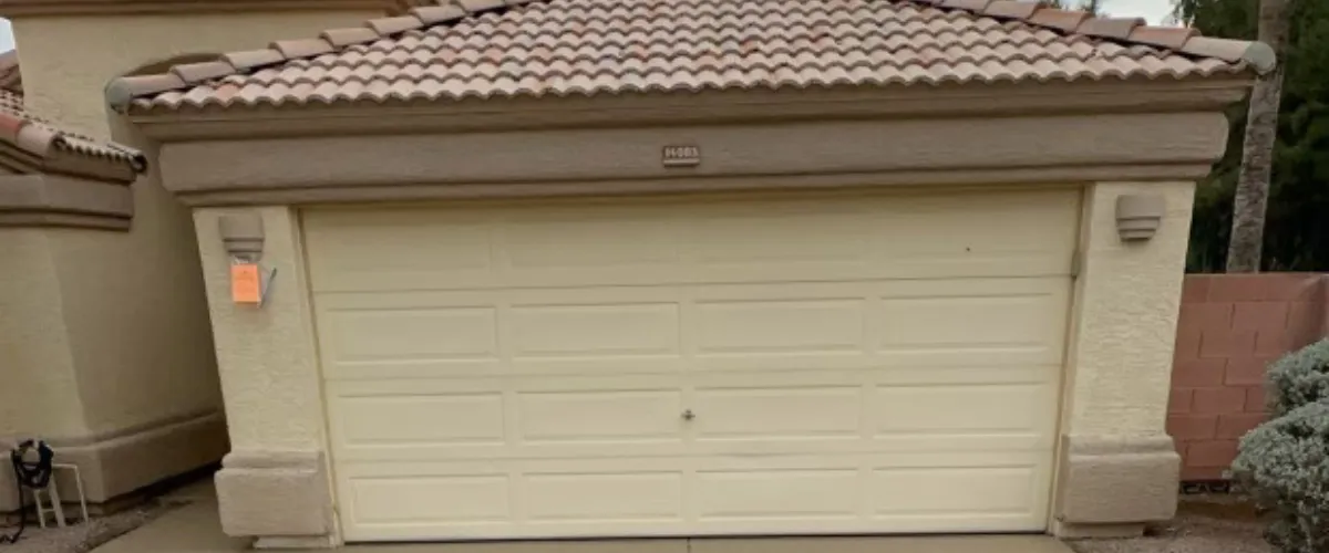 Front view of closed, beige-colored old garage door