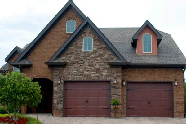 Two-car garage with wood-look garage doors on a brick and stone home exterior.