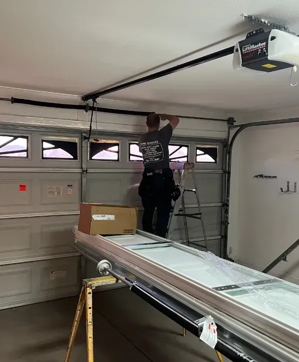 Technician working inside on garage door spring and opener setup