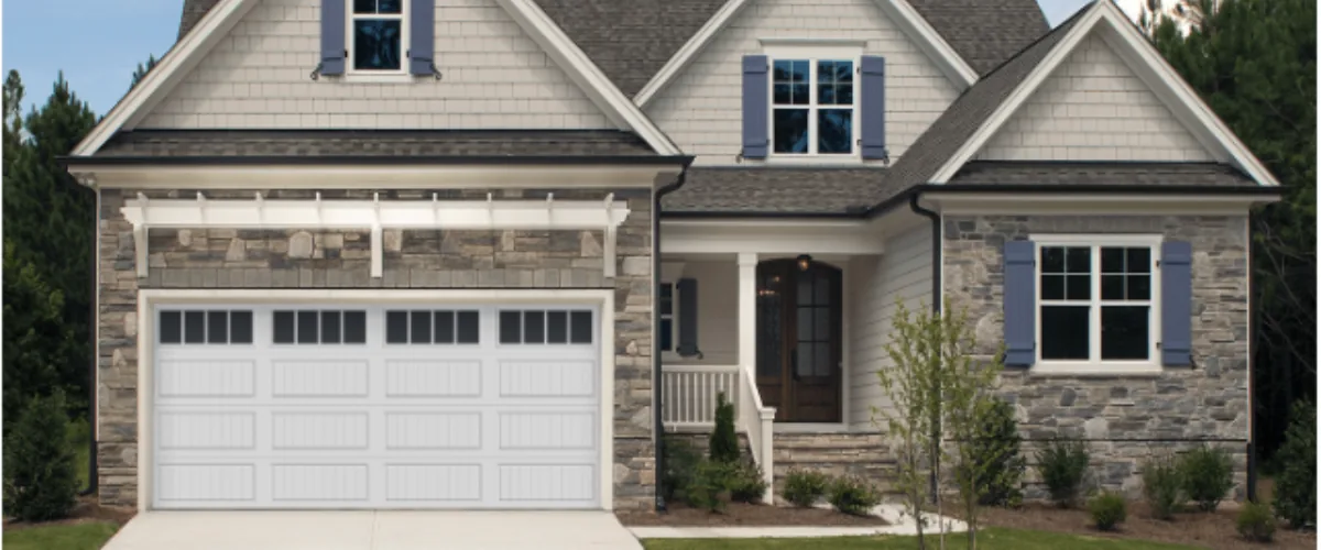 Stone-front home with white garage door, front porch, and gray shutters. Stone-front home with white garage door, front porch, and gray shutters.