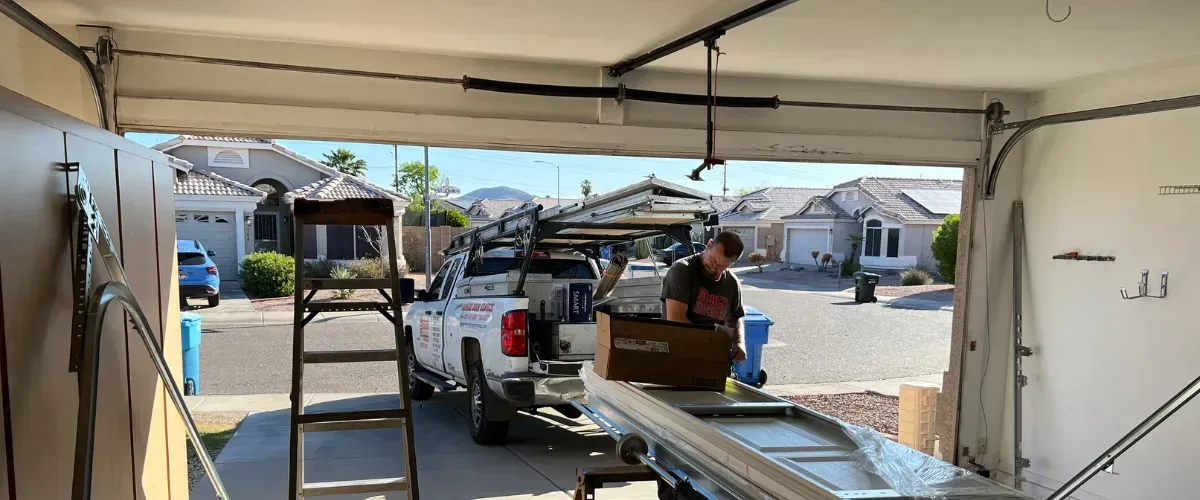 Technician unloading parts from service truck for garage door installation